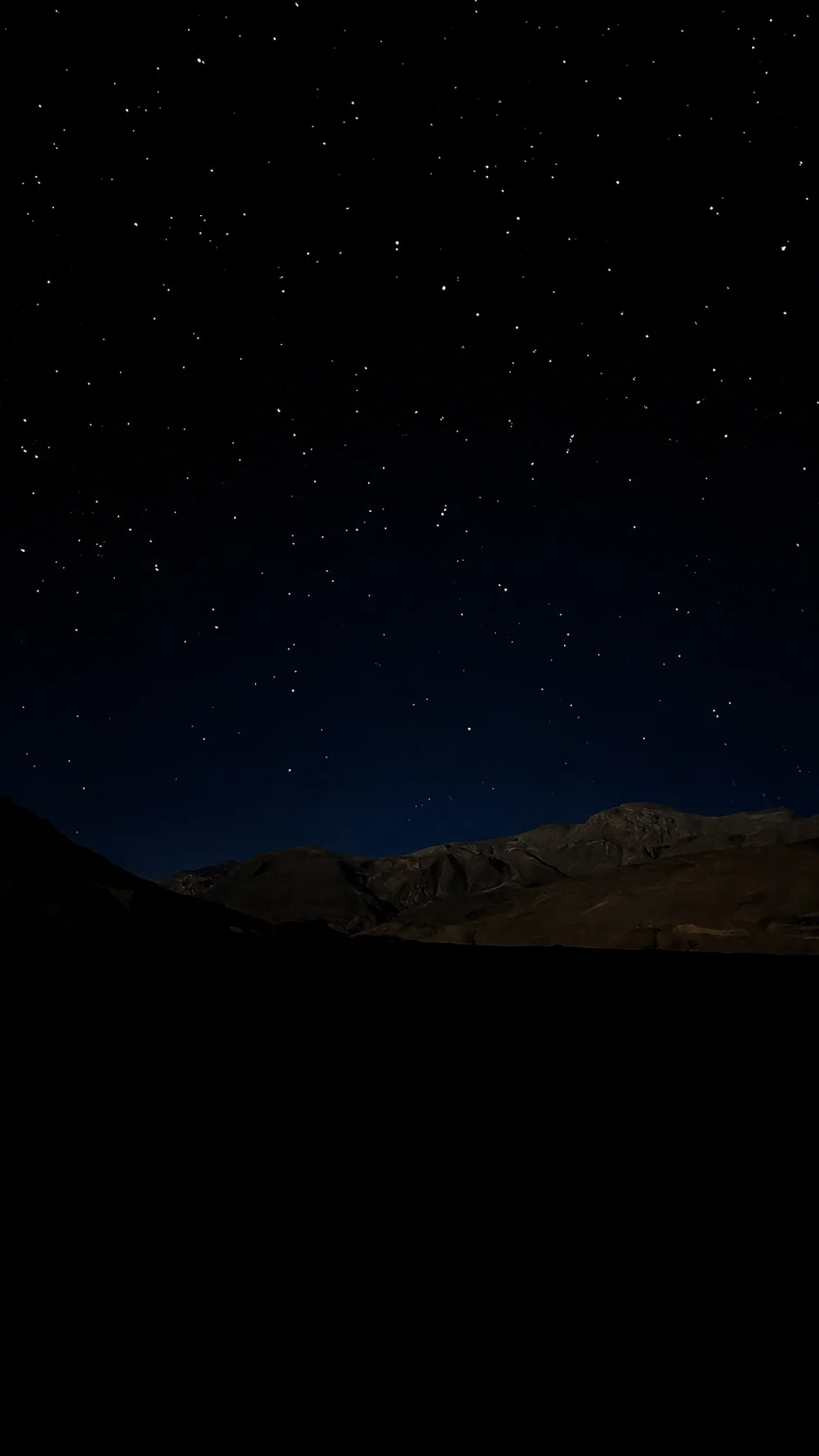 Stars above the dark mountain skyline